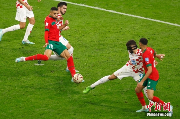 北京时间12月17日晚23点，2022卡塔尔世界杯季军赛在哈利法体育场打响，克罗地亚队迎战摩洛哥队。图为摩洛哥队球员(红)射门。中新社记者 富田 摄